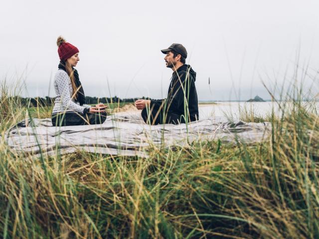 Ein Paar beim Yoga in der Bucht von Mont-Saint-Michel.