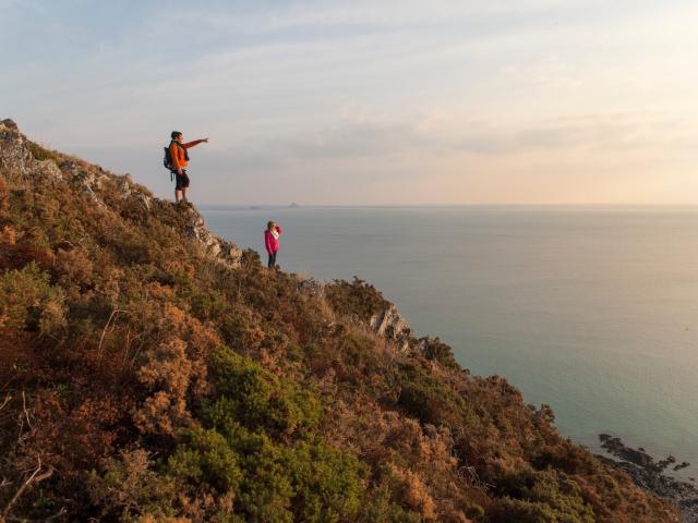 Deux randonneuses admirent la baie du Mont Saint-Michel depuis les falaises de Carolles et Champeaux