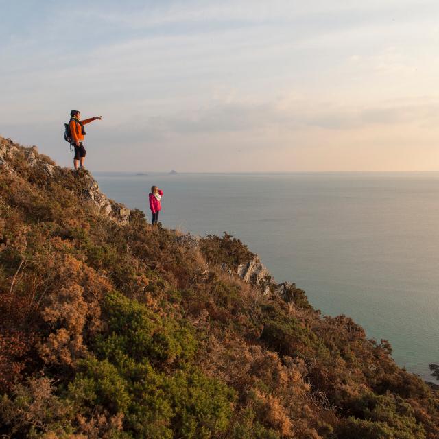 Zwei Wanderinnen bewundern die Bucht des Mont Saint-Michel von den Klippen von Carolles und Champeaux aus