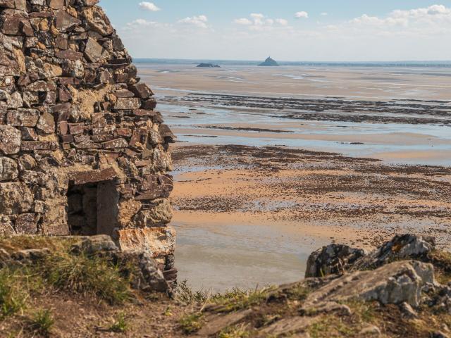 Vue sur la baie du Mont Saint-Michel à marée basse depuis la cabane Vauban et le sentier du littoral sur les falaises de Champeaux