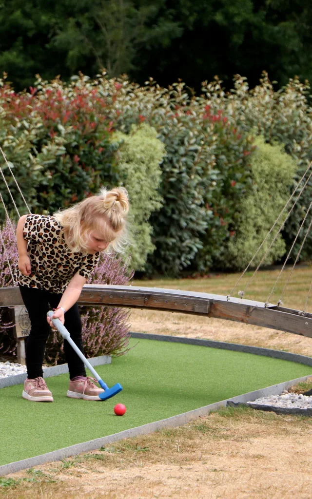 Une petite fille jour au mini-golf chez Green Mini Golf