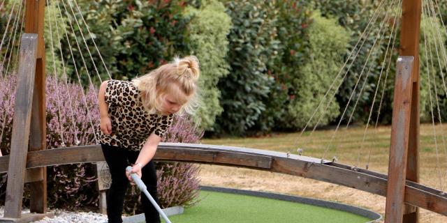 Une petite fille jour au mini-golf chez Green Mini Golf