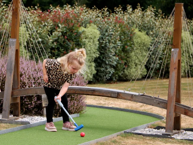 Une petite fille jour au mini-golf chez Green Mini Golf