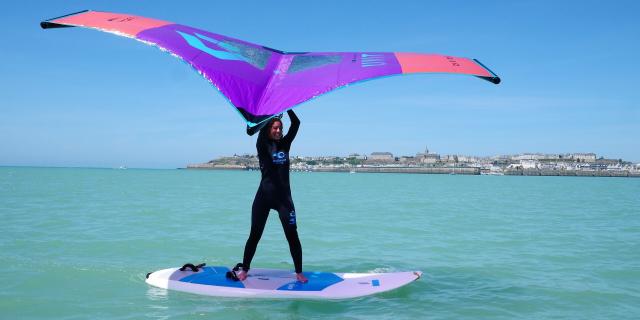 Une jeune femme pratique le Wingfoil à Granville lors d'une séance pour débutants