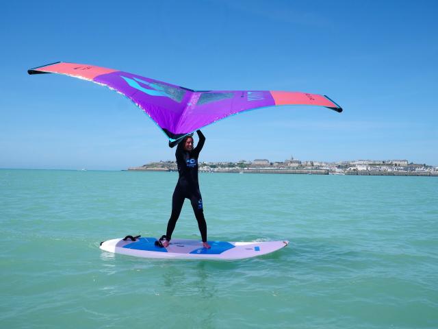 Une jeune femme pratique le Wingfoil à Granville lors d'une séance pour débutants