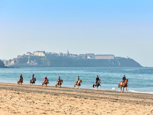 Randonneurs à cheval sur la plage