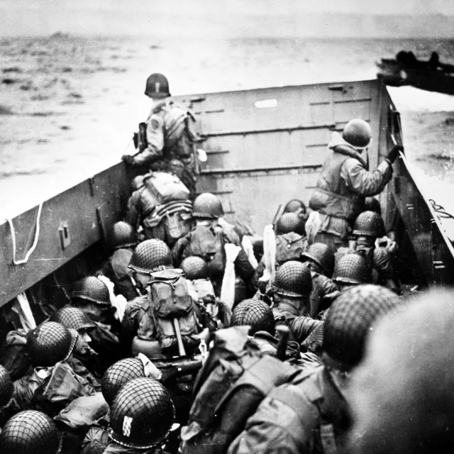 Troops crouch inside a LCVP landing craft, just before landing on Omaha Beach on D-Day, 6 June 1944.  Photograph from the U.S. Coast Guard Collection in the U.S. National Archives.