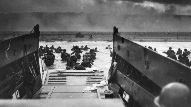 Army troops wade ashore on Omaha Beach during the D-Day landings, 6 June 1944. They were brought to the beach by a Coast Guard manned LCVP.  Photograph from the U.S. Coast Guard Collection in the U.S. National Archives.